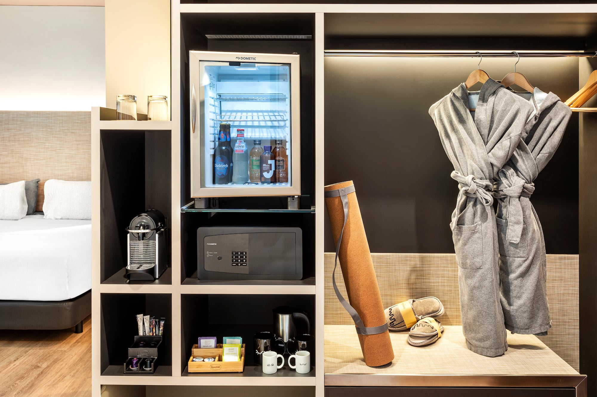 a room with a small refrigerator and a robe