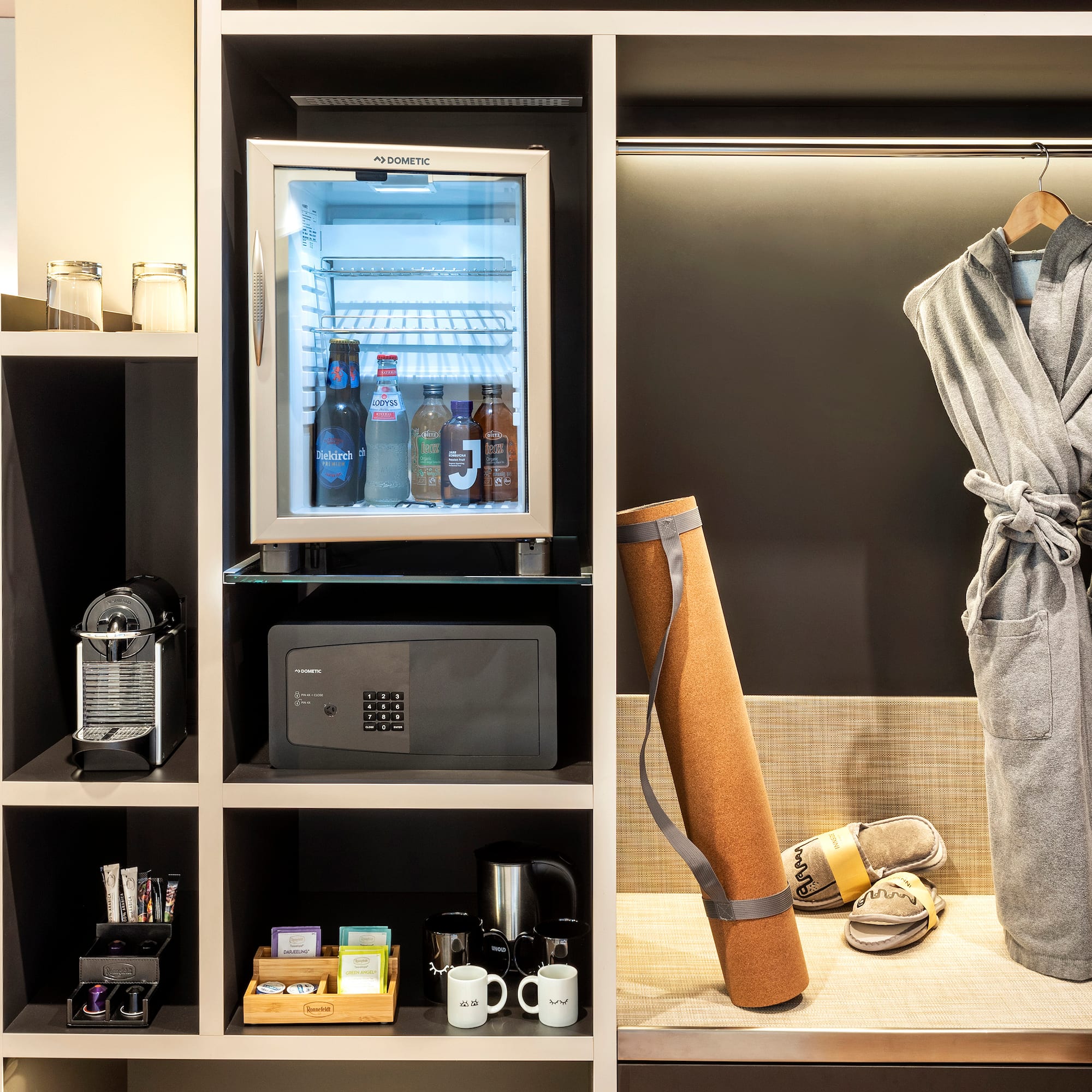 a room with a small refrigerator and a robe