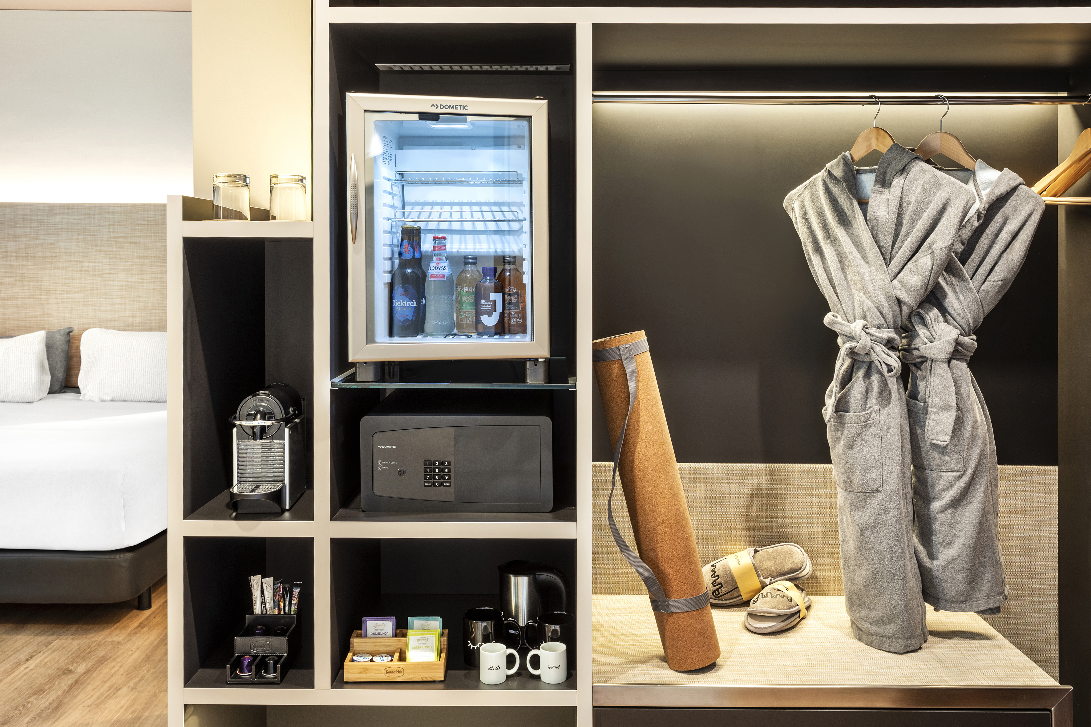 Hotel room with mini-fridge, coffee machine, safe, bathrobes, yoga mat.
