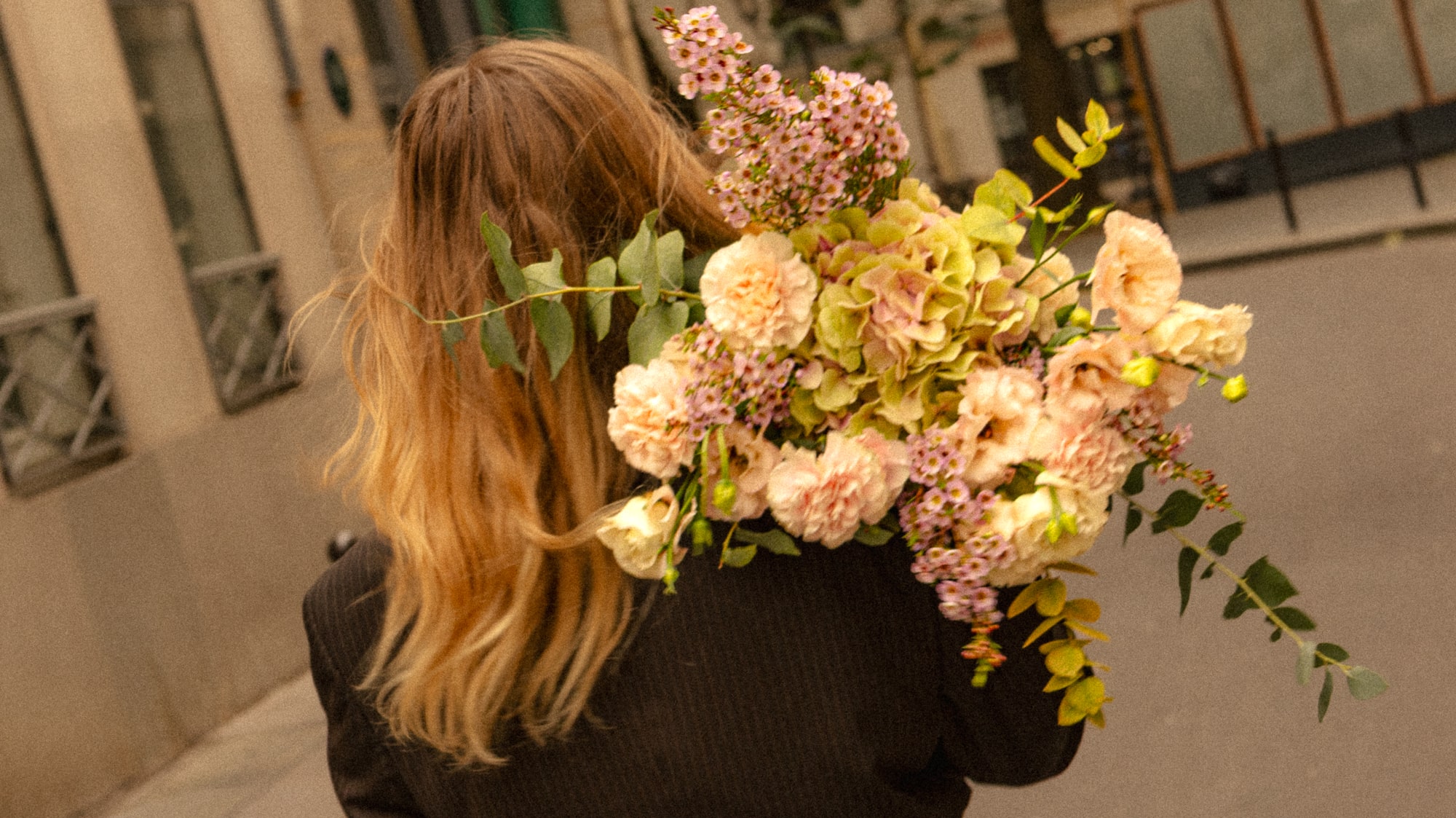 a woman carrying a bouquet of flowers