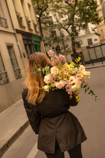 a woman carrying a bouquet of flowers