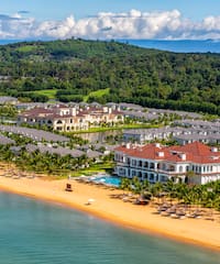 a beach with a large building and a pool on it