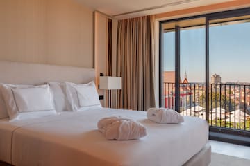 a bed with white sheets and towels on it