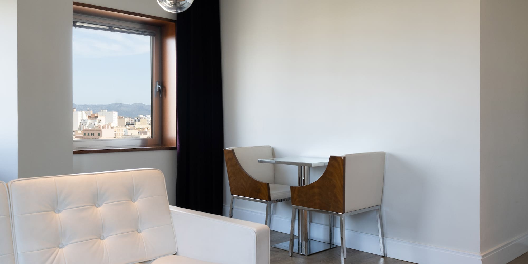 a white couch and chair in a room with a window