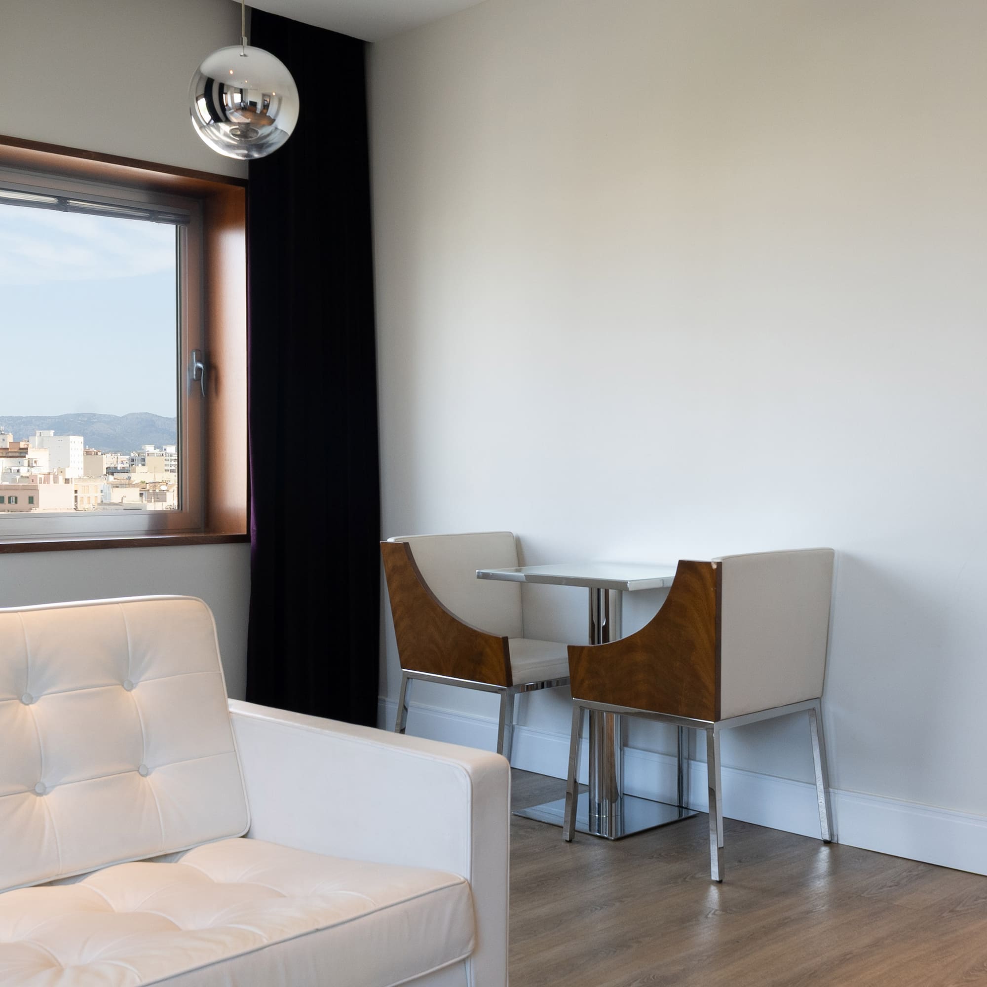 a white couch and chair in a room with a window