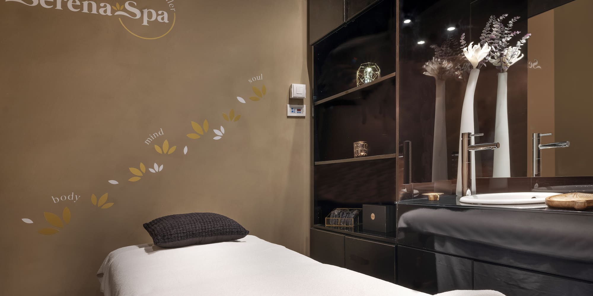 a massage room with a bed and a mirror
