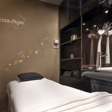 a massage room with a bed and a mirror