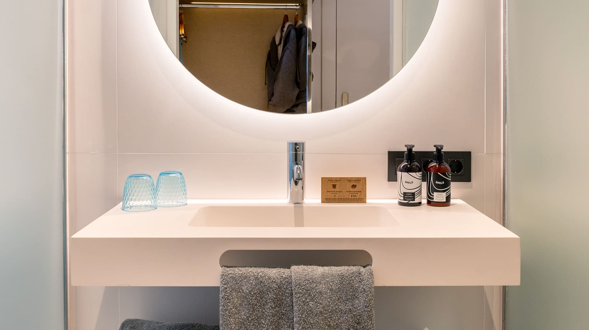 a bathroom sink with a round mirror