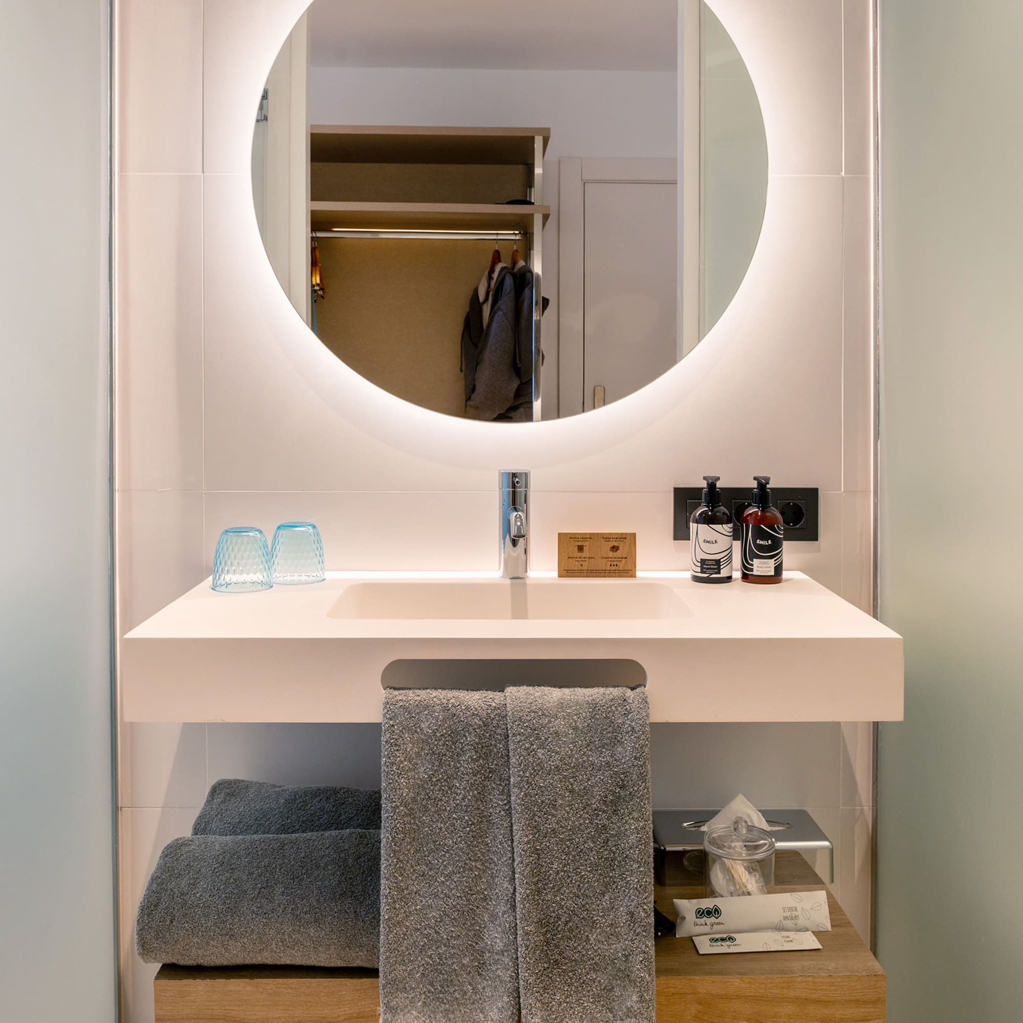 a bathroom sink with a round mirror