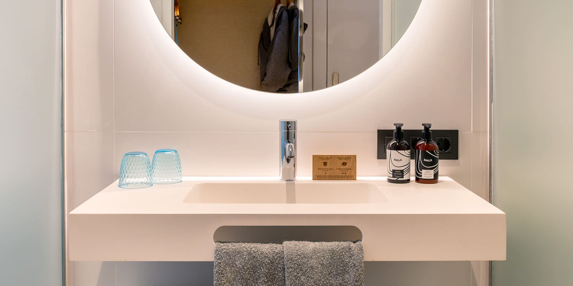 a bathroom sink with a round mirror