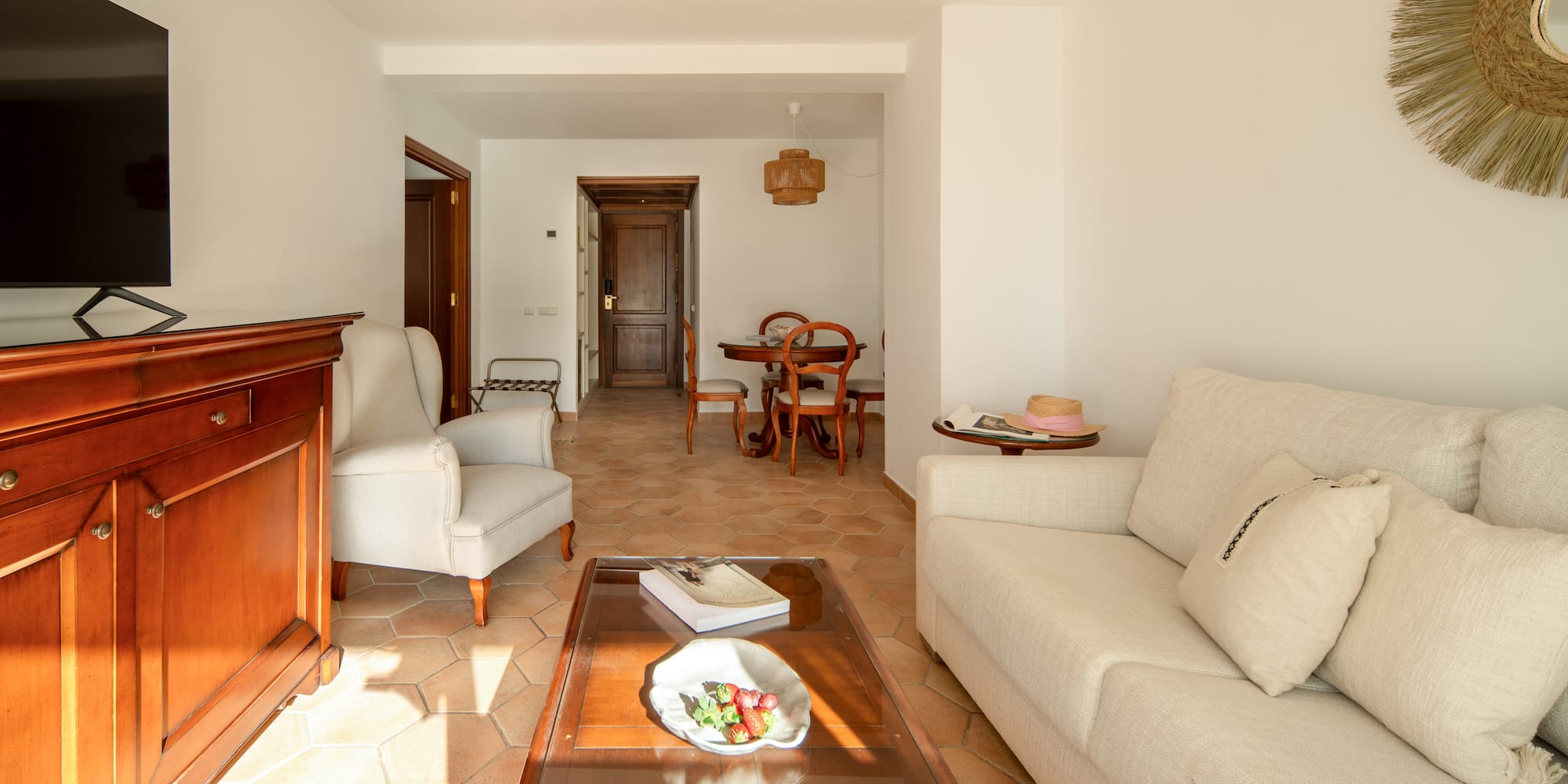 a living room with white furniture and a glass coffee table