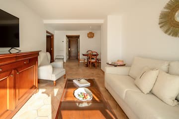 a living room with white furniture and a glass coffee table