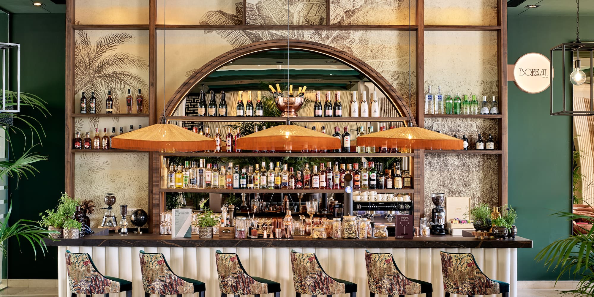a bar with a row of chairs and bottles