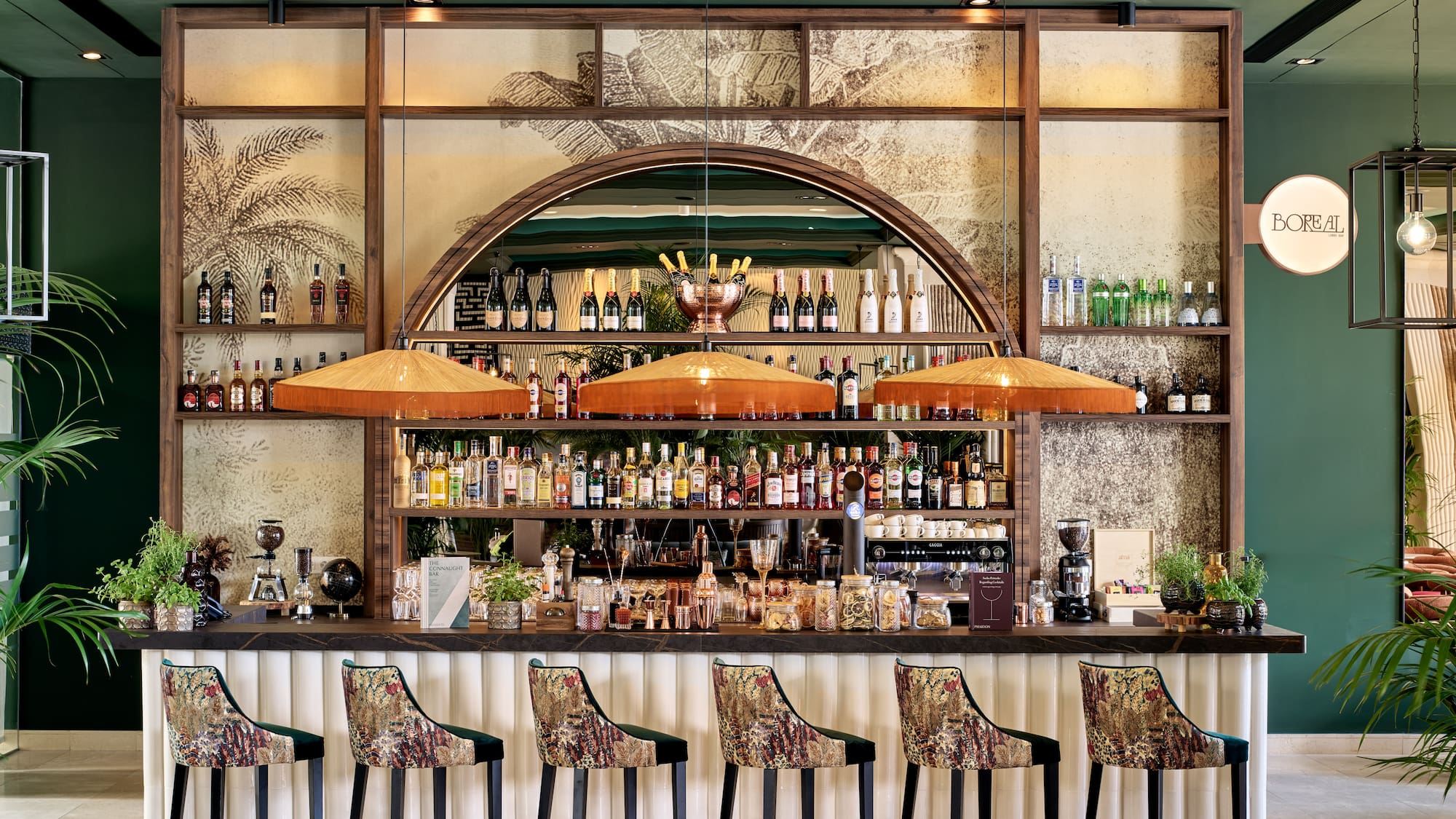 a bar with a row of chairs and bottles