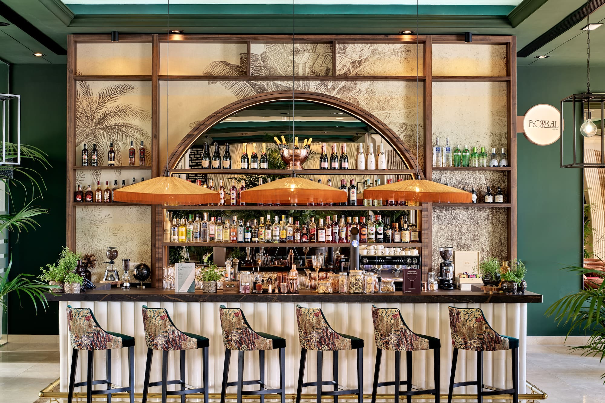 a bar with a row of chairs and bottles