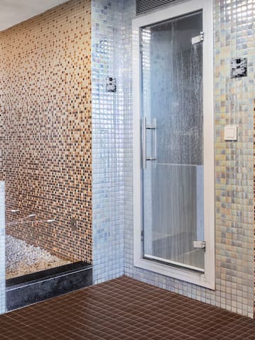 a bathroom with a shower and a shower stall.