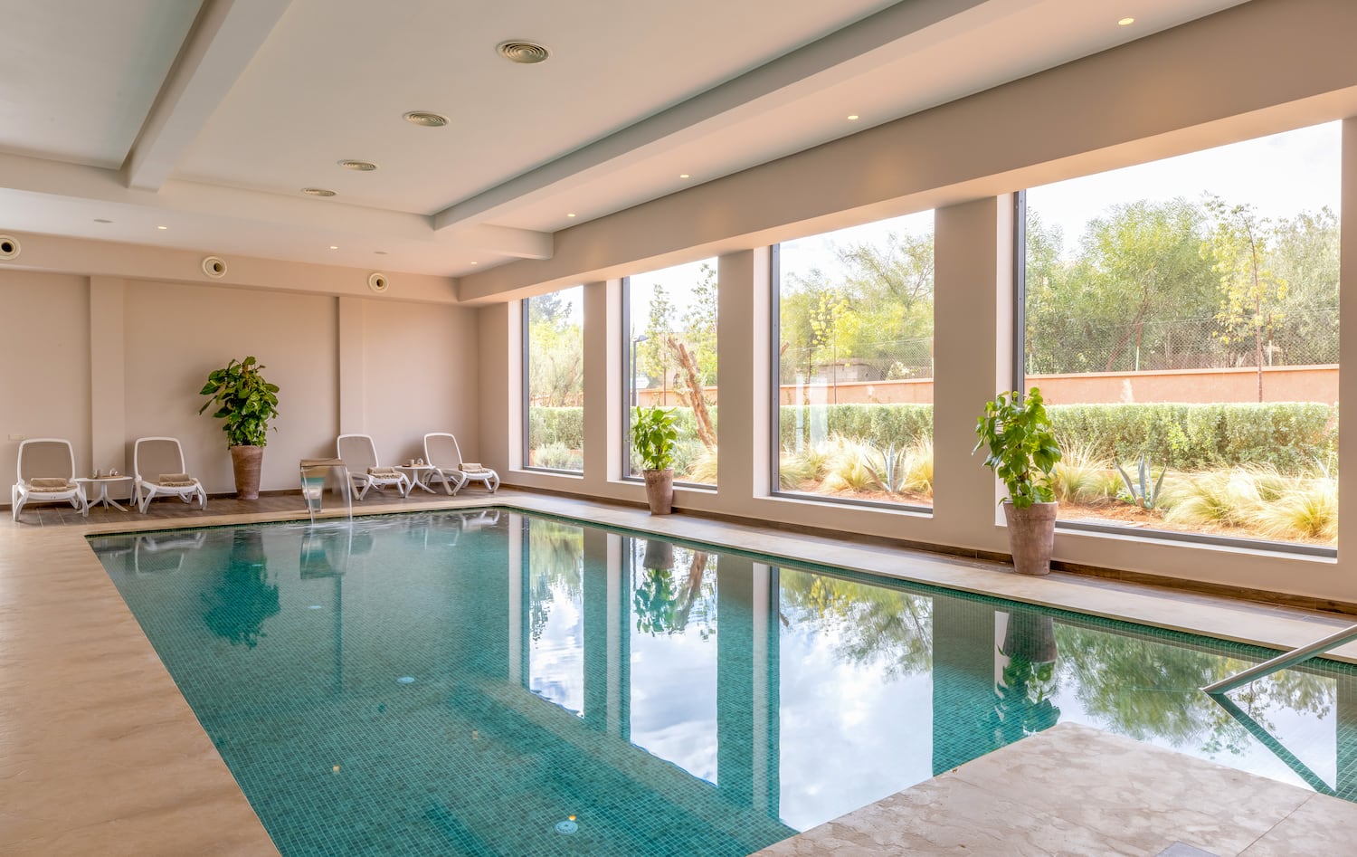 a indoor pool with windows and plants
