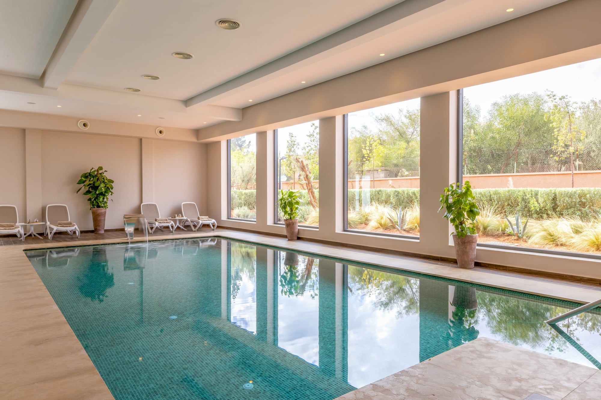 a indoor pool with windows and plants