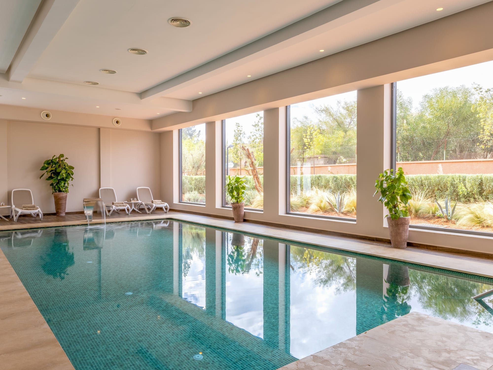 a indoor pool with windows and plants