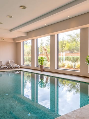 a indoor pool with windows and plants