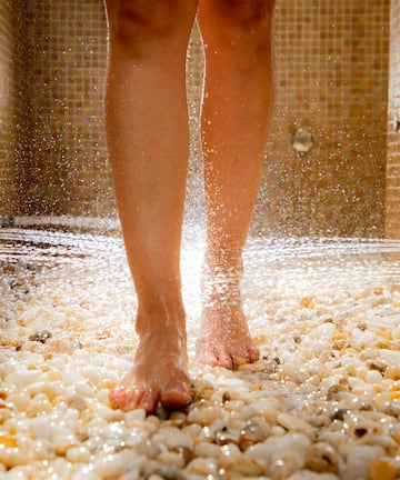 a person's legs walking on a shower
