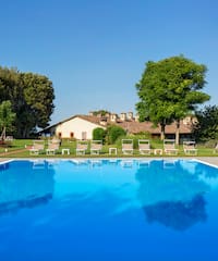a pool with chairs and trees in the background
