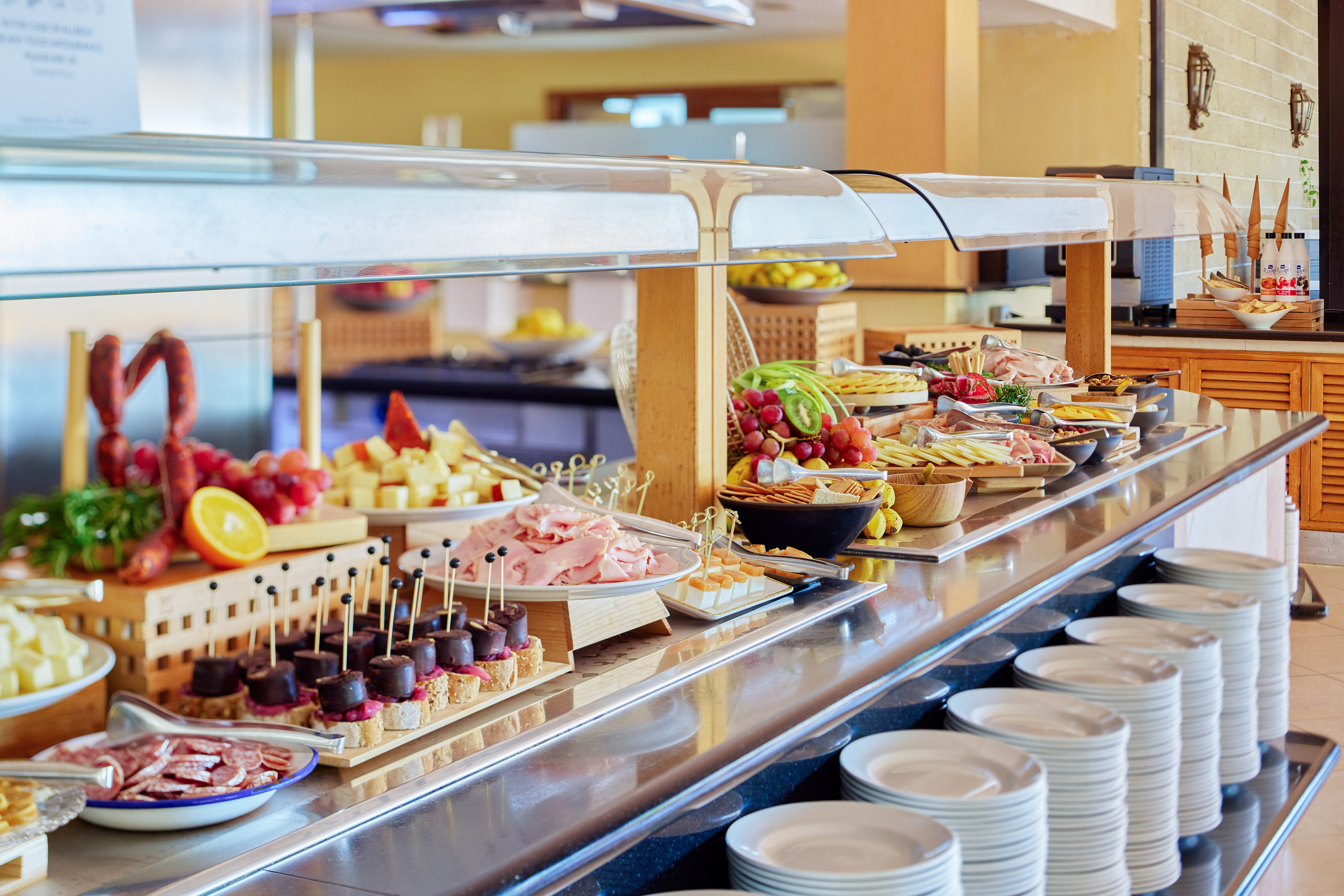 Hotel buffet with charcuterie, cheeses, fresh fruits, and savory appetizers.
