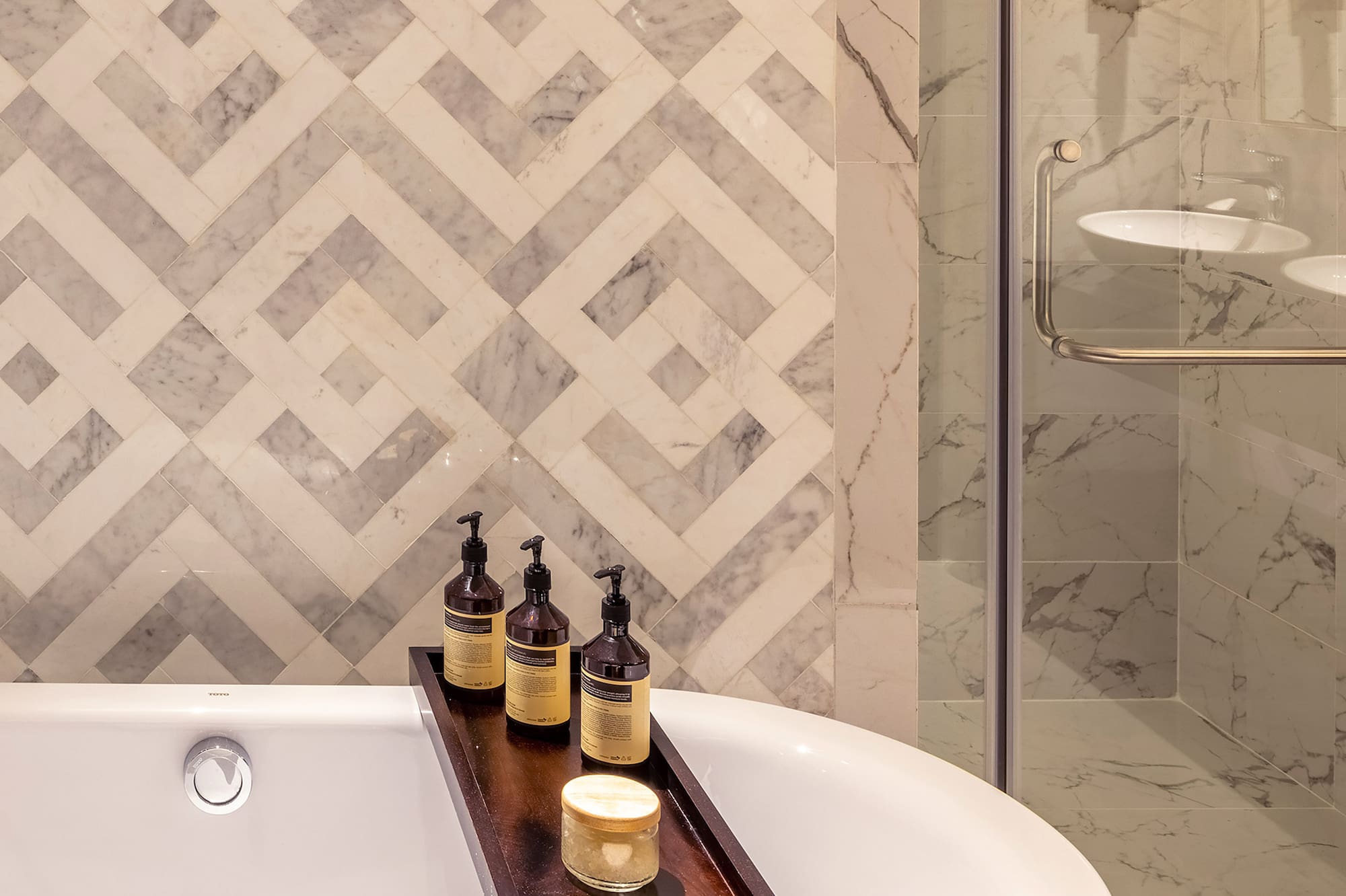 a bathtub with candles and soap on a tray