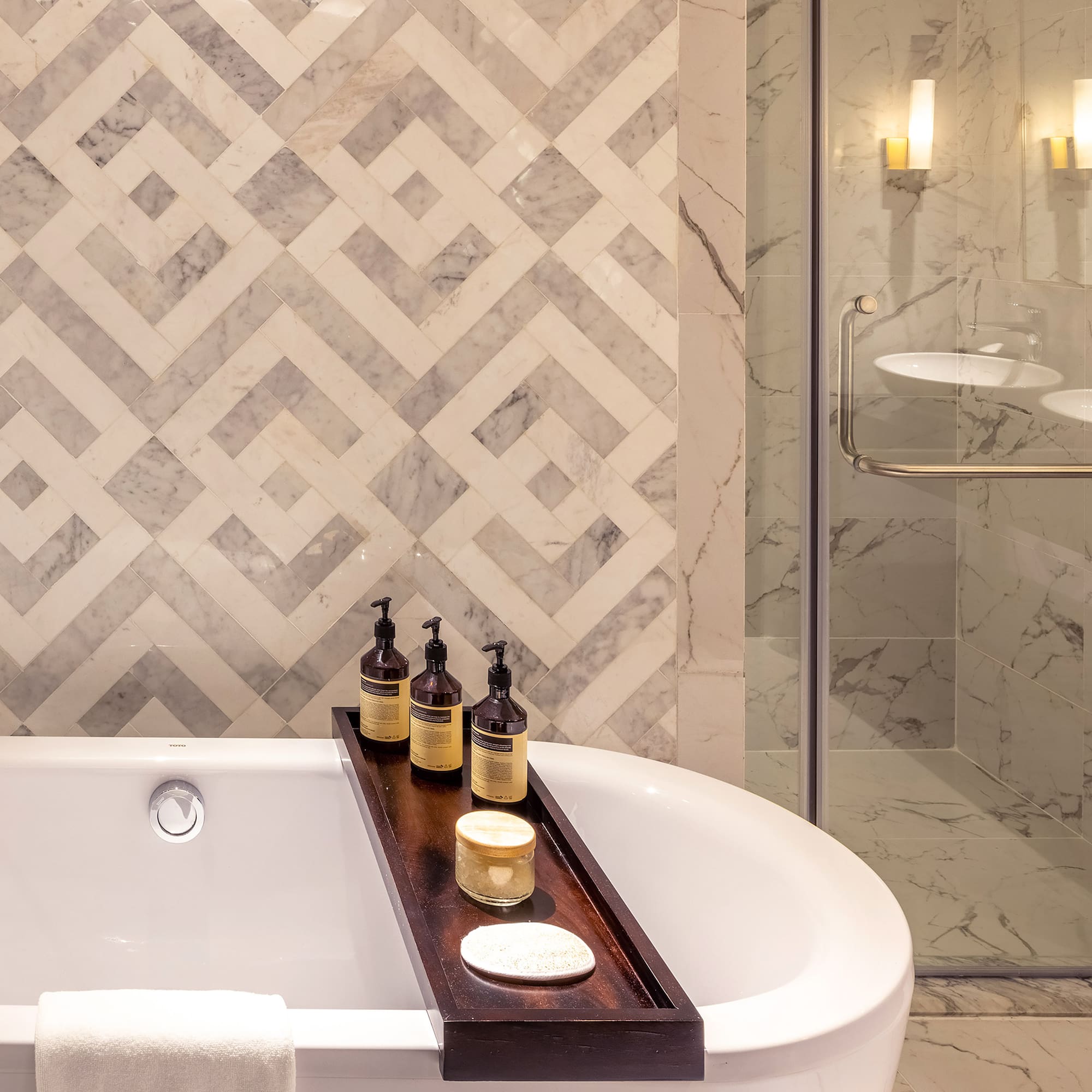 a bathtub with candles and soap on a tray