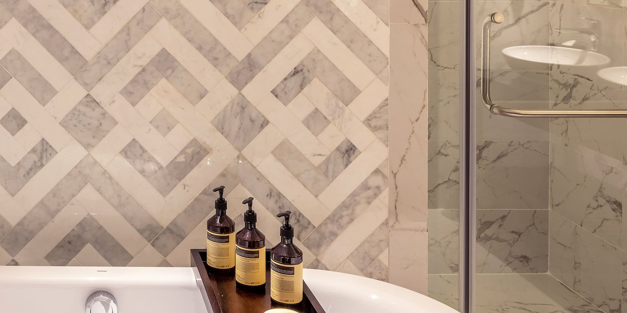 a bathtub with candles and soap on a tray