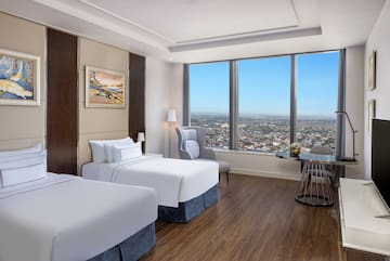 a room with two beds and a table and chairs