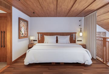 a bed with white sheets and a wood floor