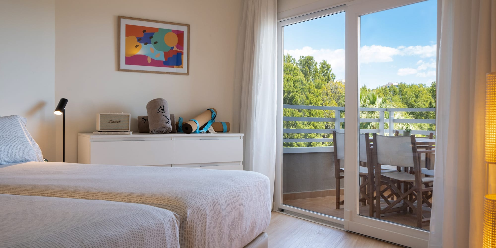 a bedroom with a glass door and a table and chairs