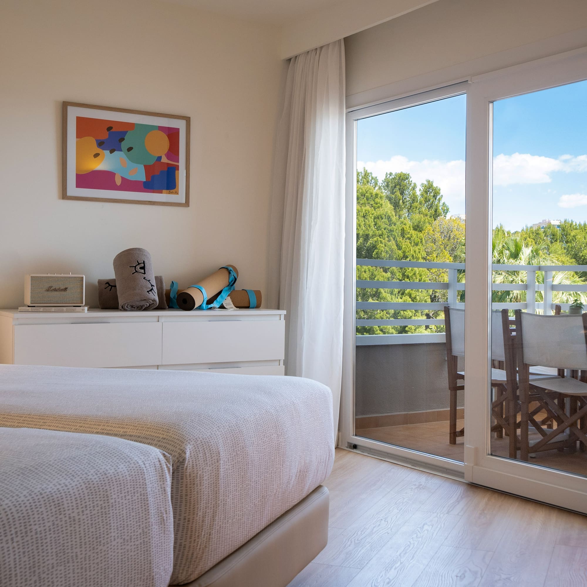 a bedroom with a glass door and a table and chairs