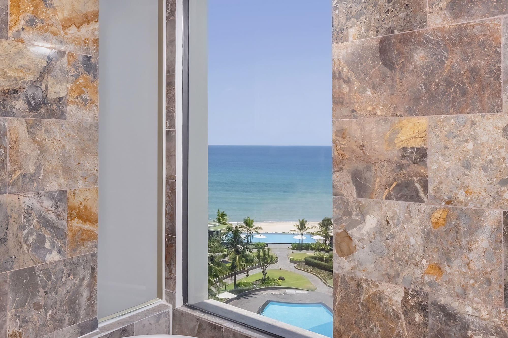 a bathroom with a tub and a view of the ocean