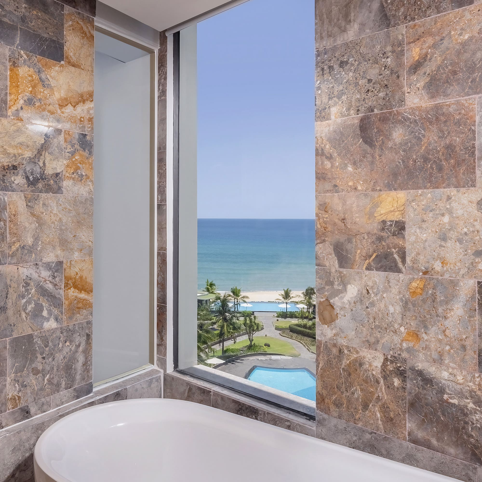 a bathroom with a tub and a view of the ocean