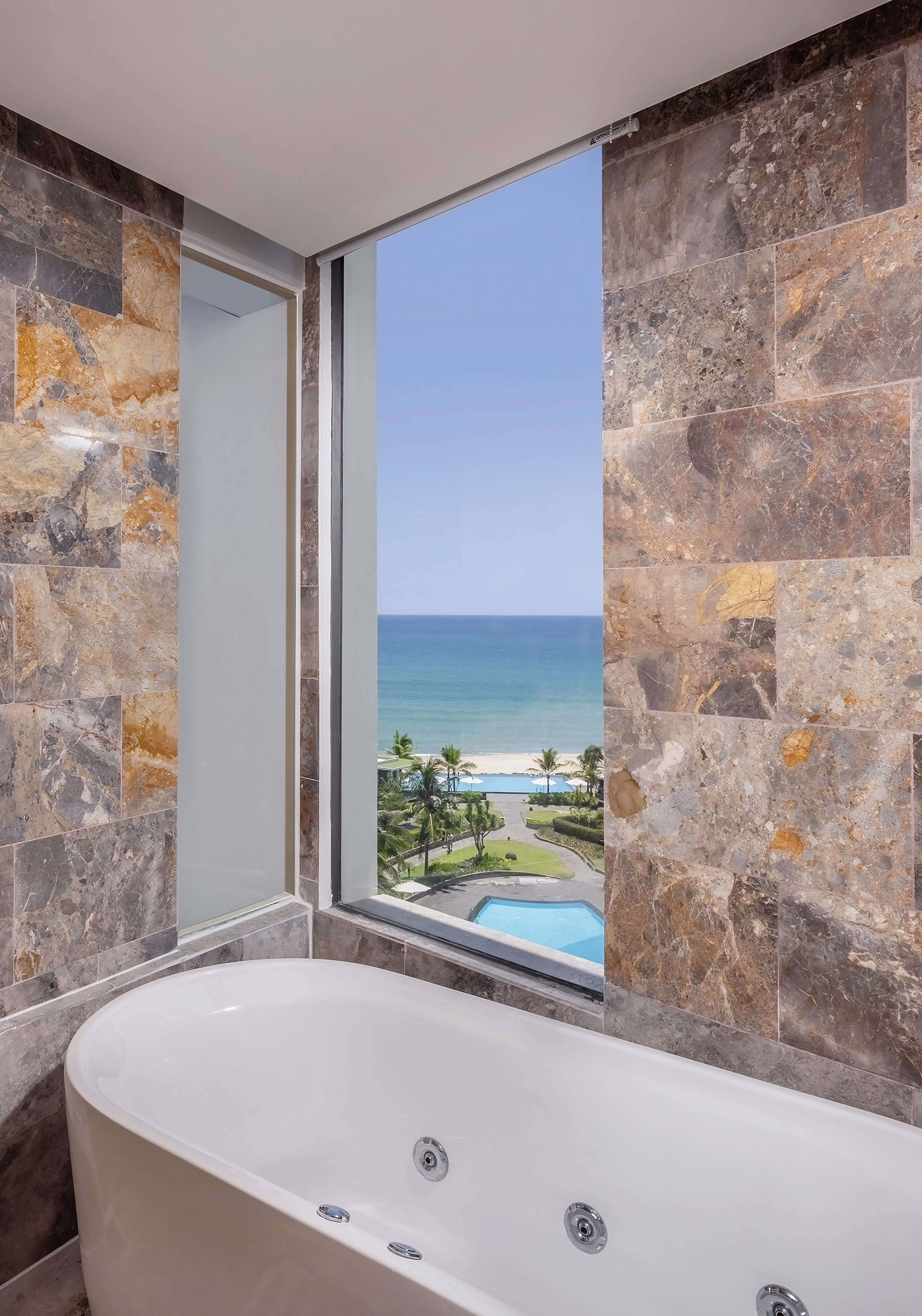 a bathroom with a tub and a view of the ocean