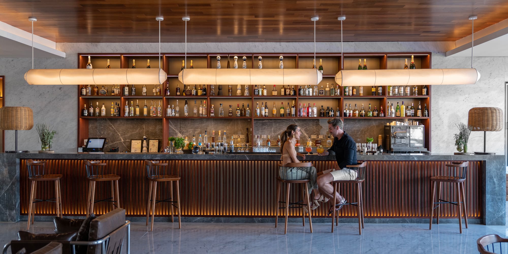 a man and woman sitting at a bar