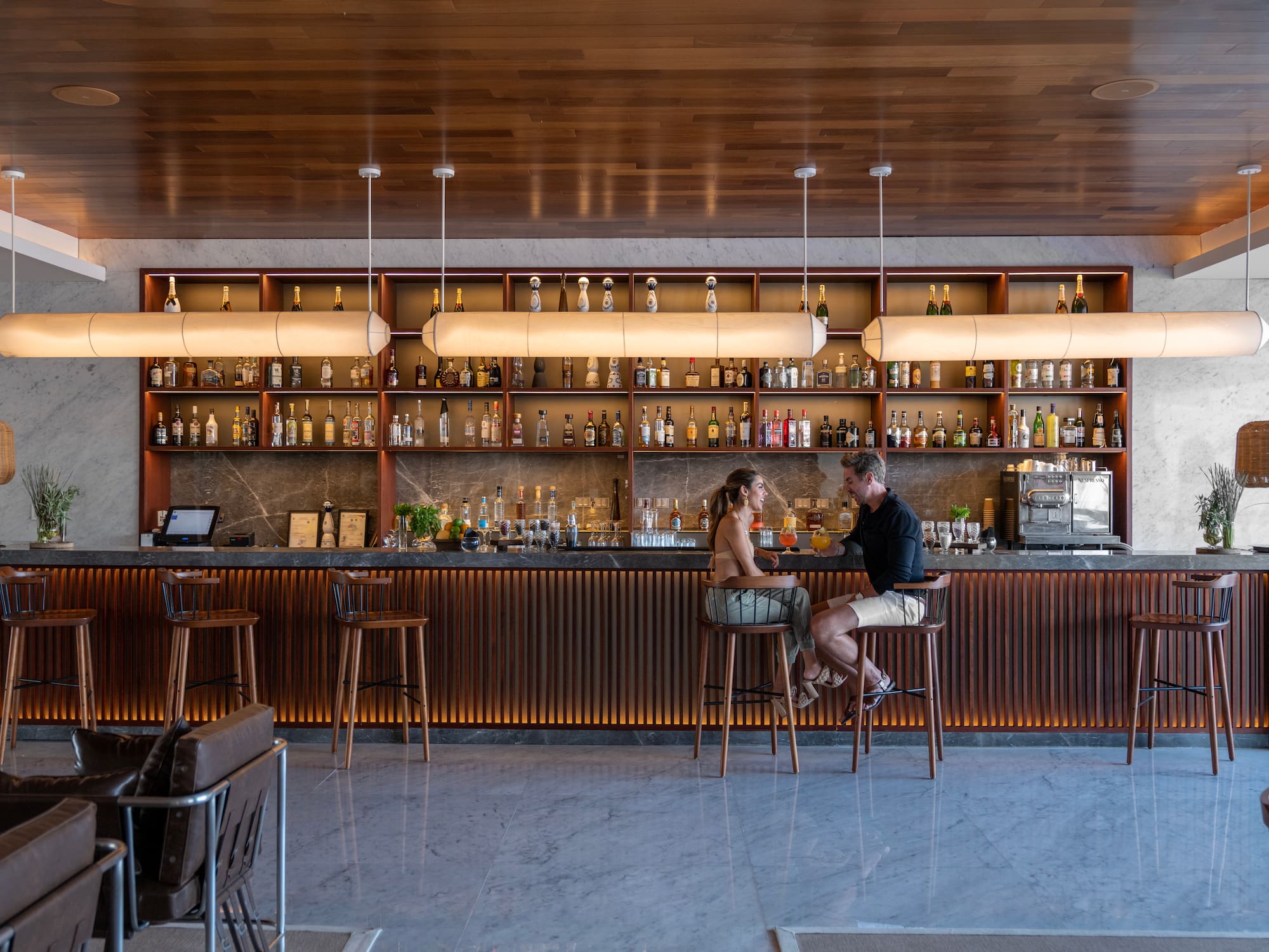 a man and woman sitting at a bar