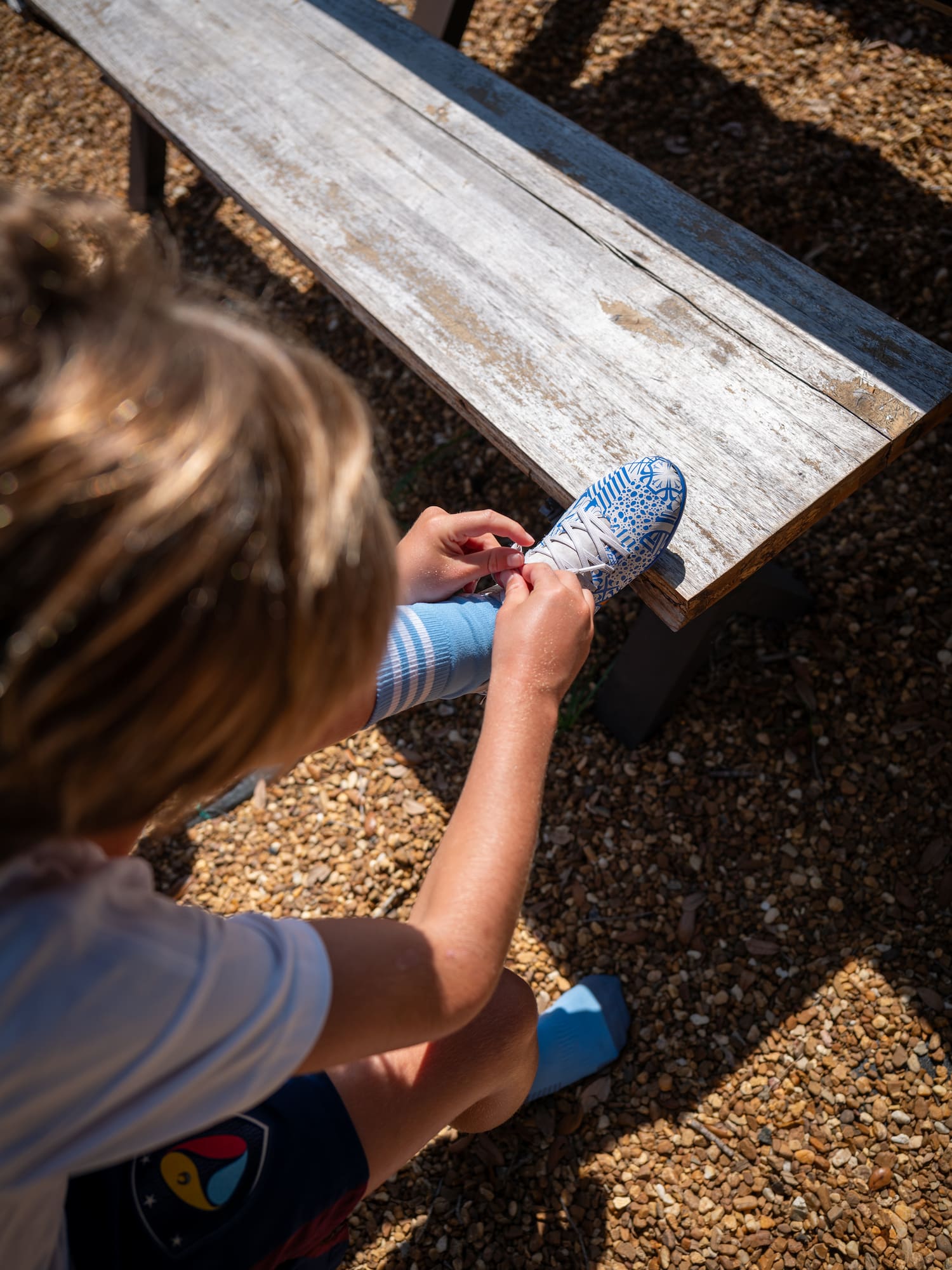 a person tying shoelaces on a bench