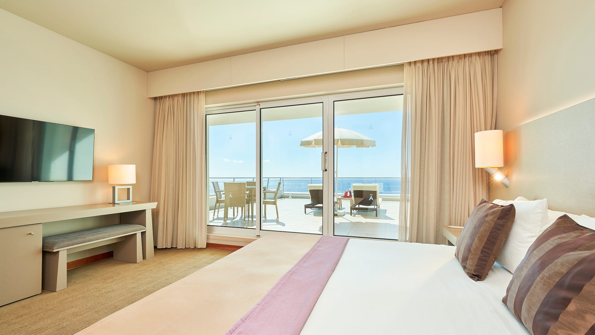 a bedroom with a large bed and a glass door