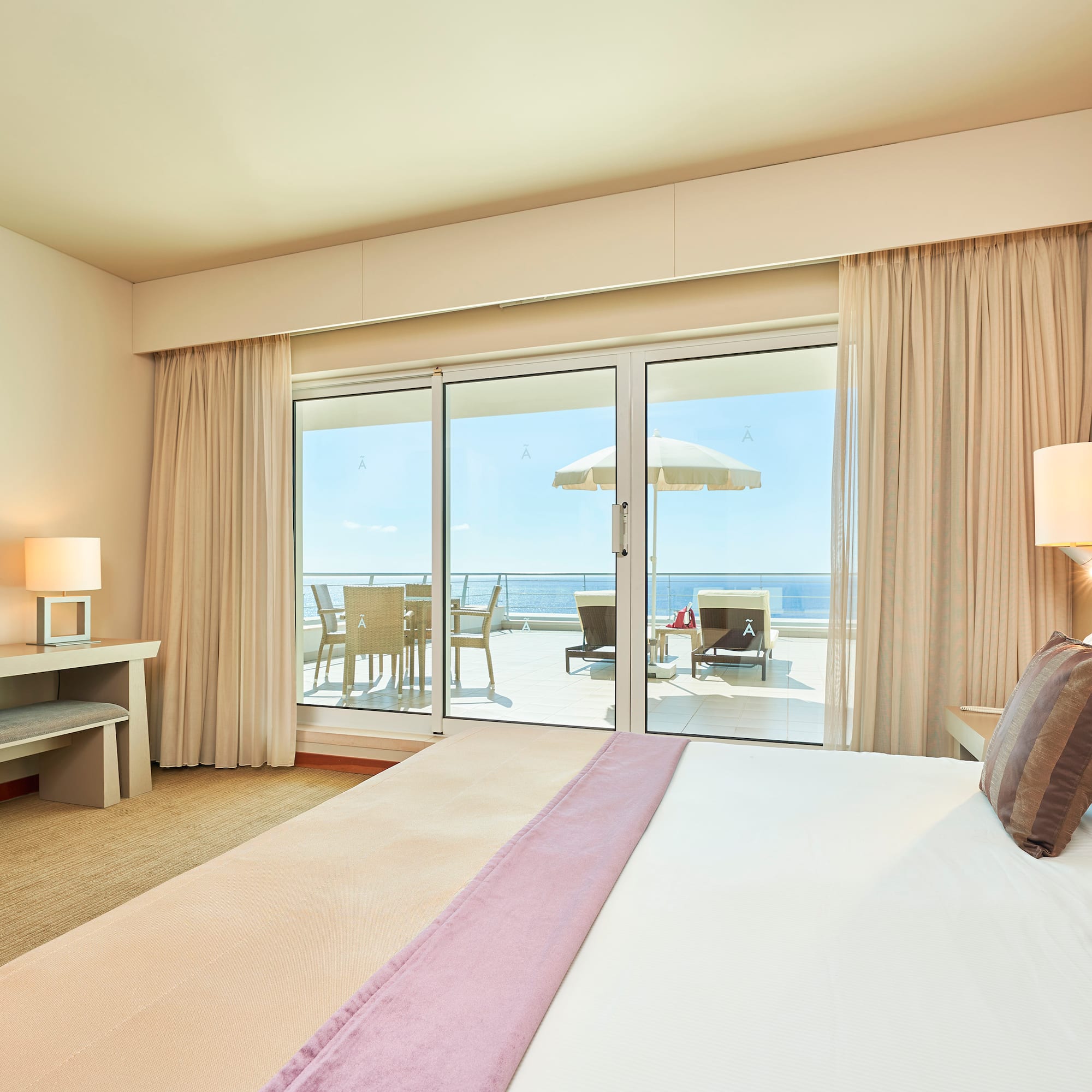 a bedroom with a large bed and a glass door