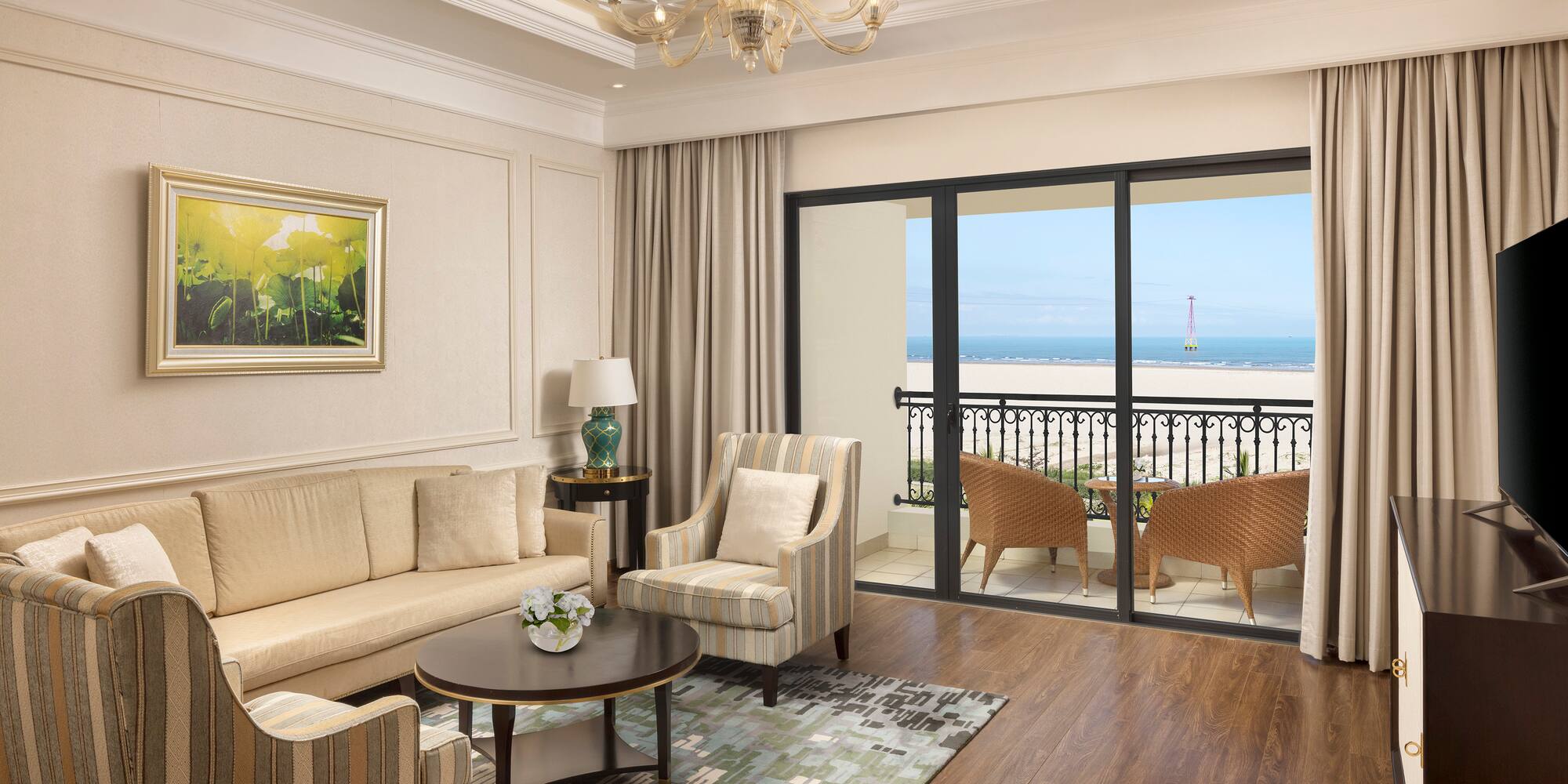 a living room with a balcony overlooking the ocean