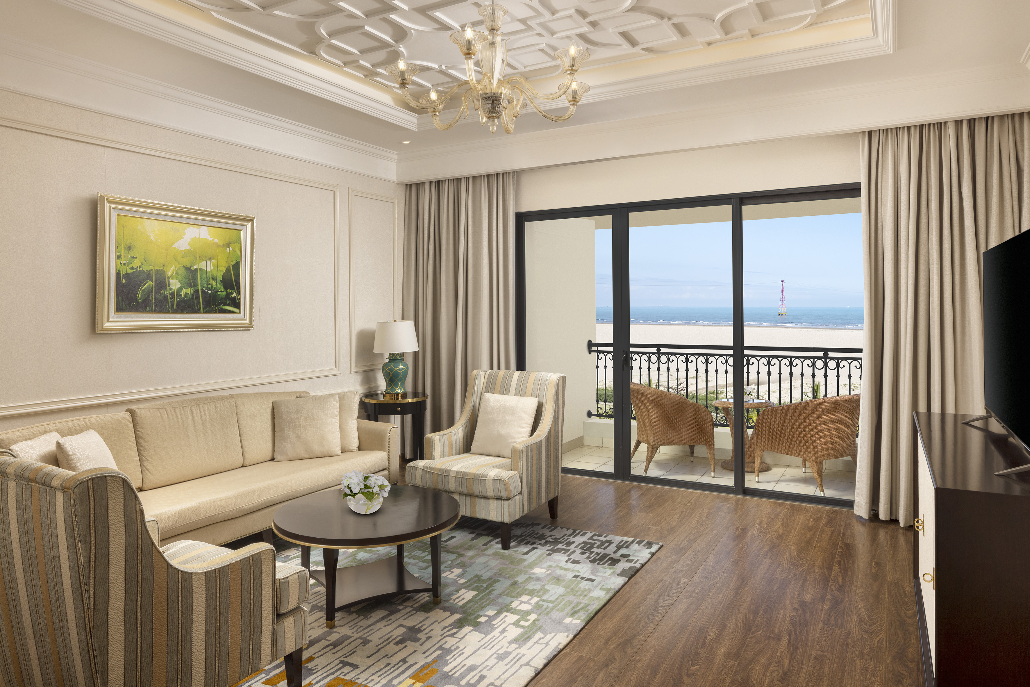 a living room with a balcony overlooking the ocean