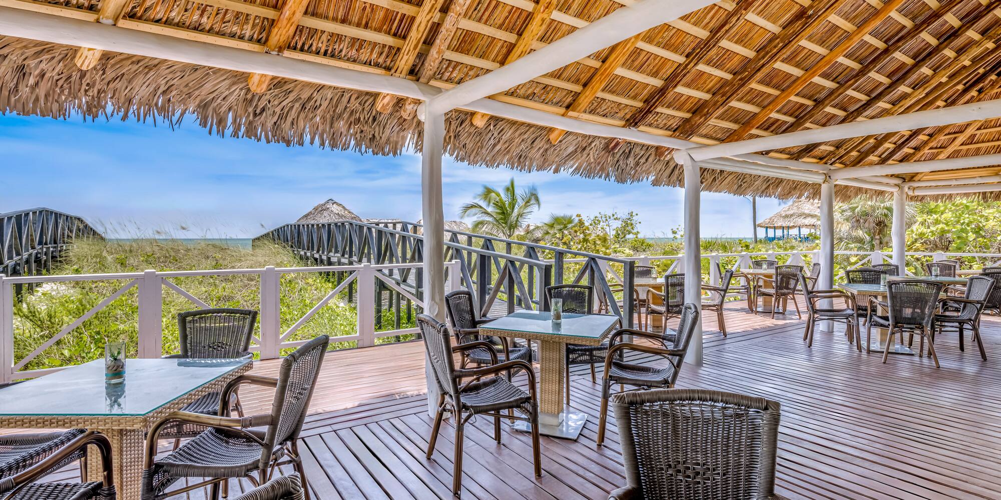 a deck with chairs and a thatched roof