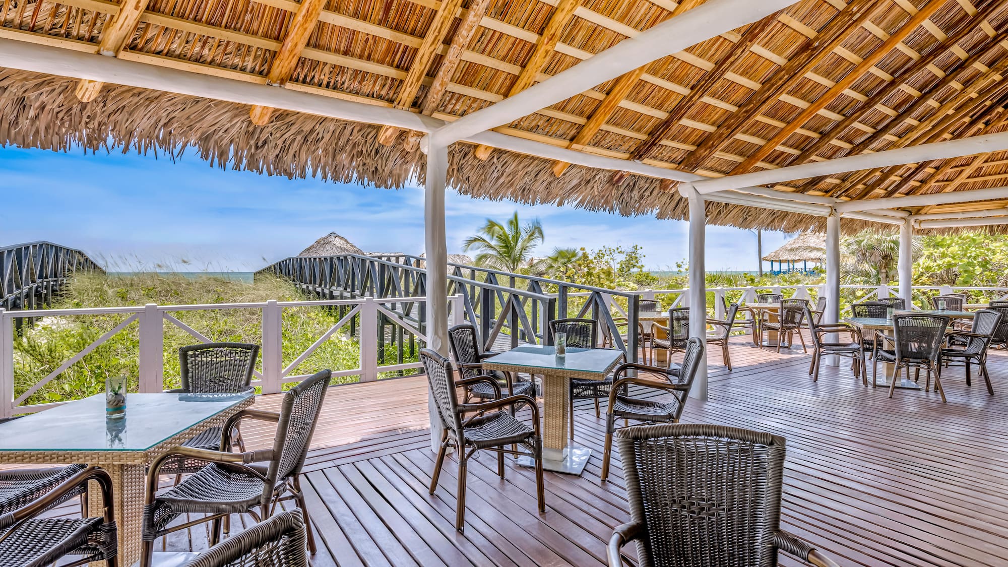 a deck with chairs and a thatched roof