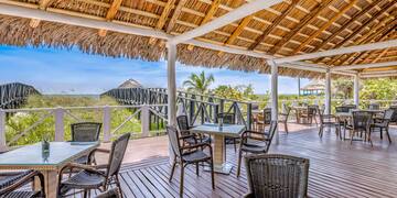 a deck with chairs and a thatched roof