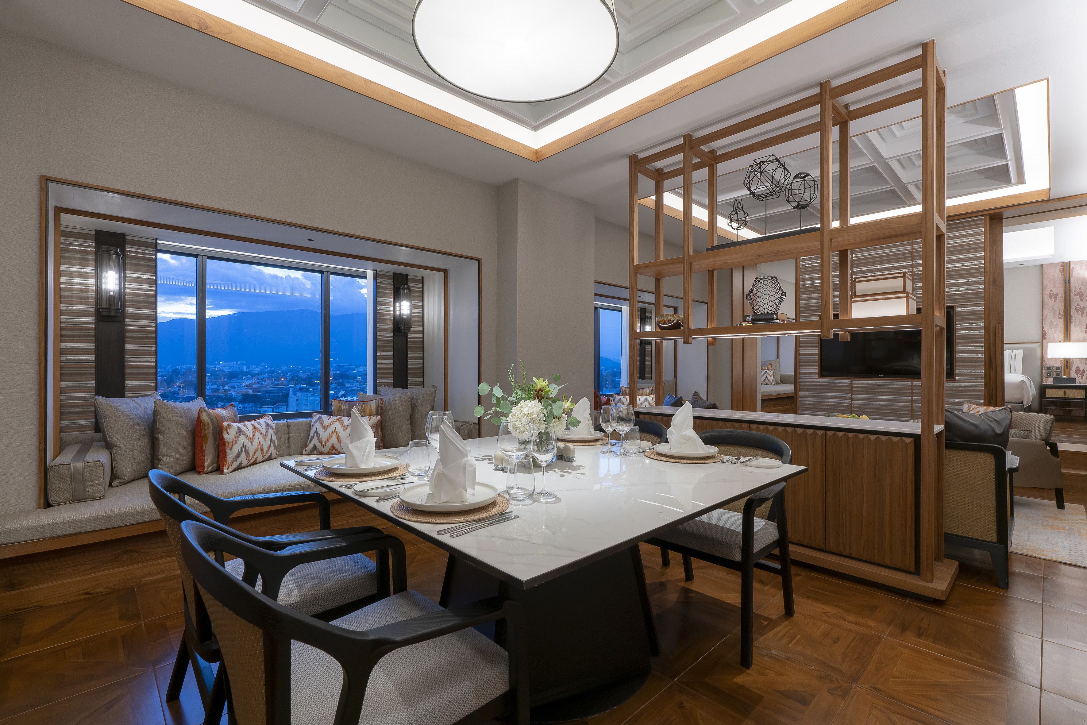 Modern hotel dining room with set marble table, city view, and wooden interior.