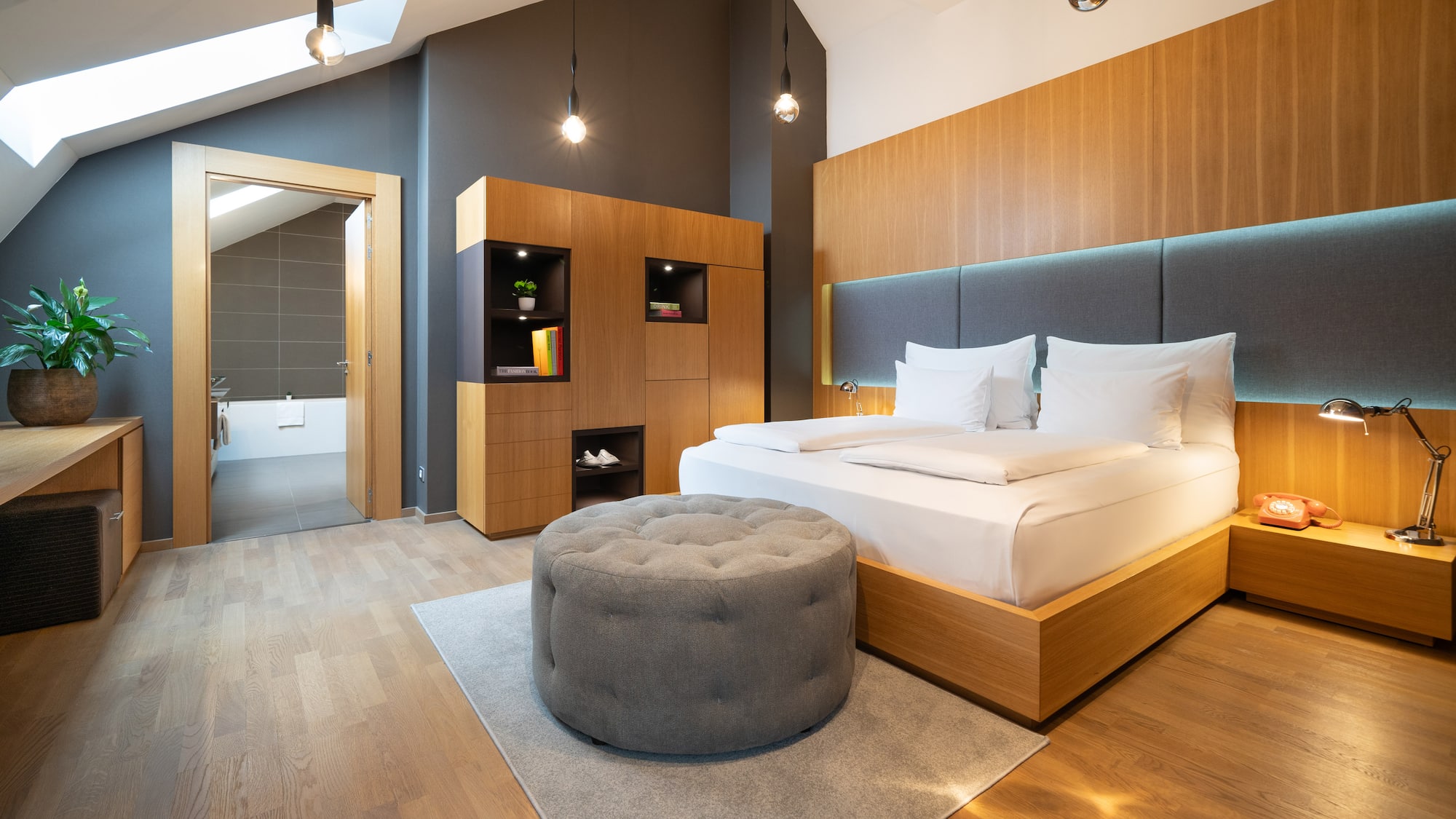 a bedroom with a bed and a round ottoman