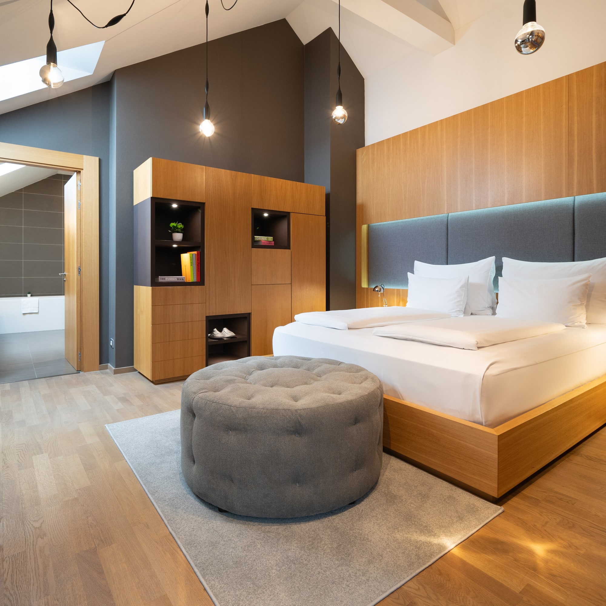 a bedroom with a bed and a round ottoman